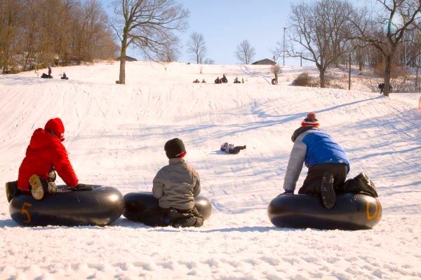 kids on snow hill tubing