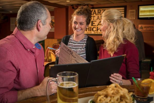 people with menu ordering food at a supper club