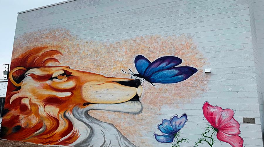 Brillion Mural with an image of a lion with a butterfly on its nose.