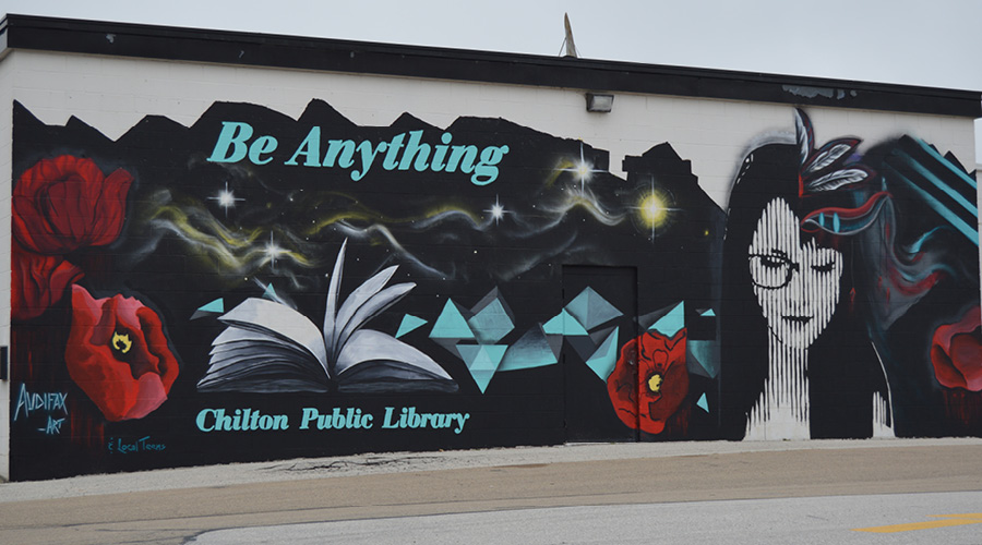 Chilton Library Mural with the image of a woman, book, and flowers.